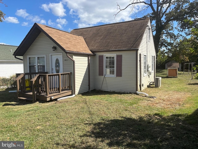 view of front of home featuring a deck, a storage unit, and a front lawn