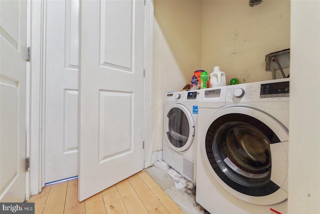 washroom with washer and dryer and light wood-type flooring