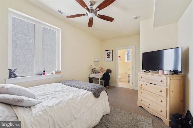 bedroom featuring connected bathroom, light colored carpet, and ceiling fan