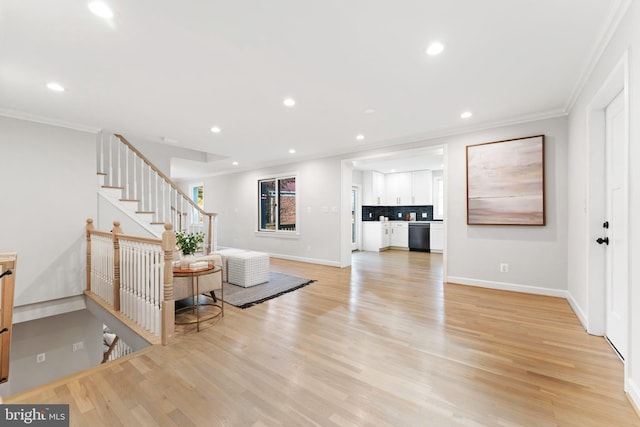 living room with ornamental molding and light hardwood / wood-style floors