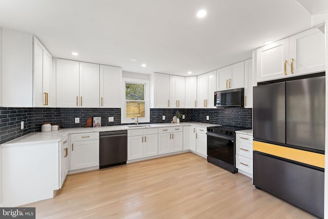 kitchen with white cabinets, backsplash, light wood-type flooring, sink, and stainless steel appliances