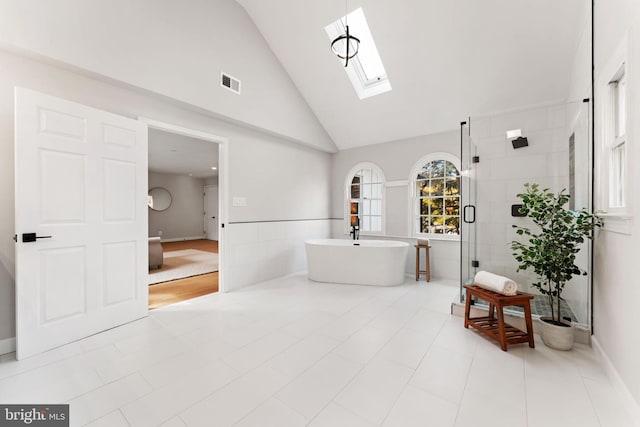 bathroom with shower with separate bathtub, high vaulted ceiling, tile patterned floors, and a skylight