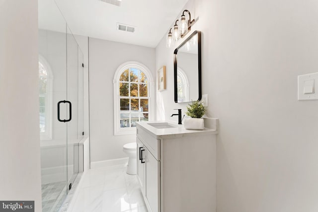 bathroom with vanity, toilet, and a shower with door