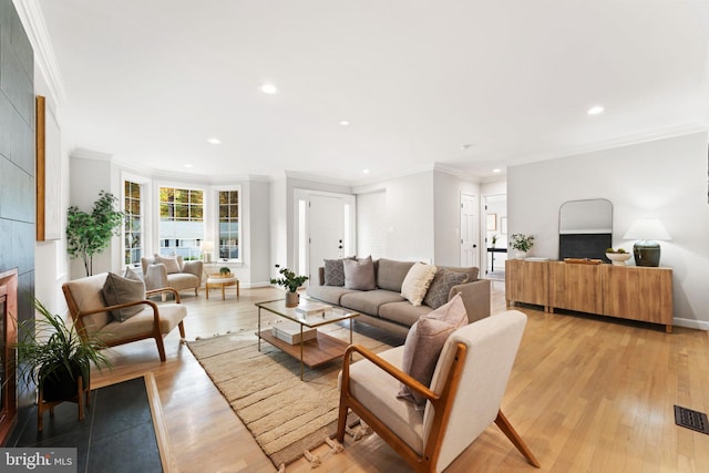 living room with ornamental molding and light wood-type flooring