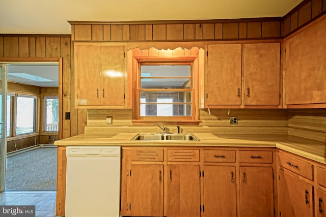 kitchen featuring wood walls, dishwasher, tasteful backsplash, and sink