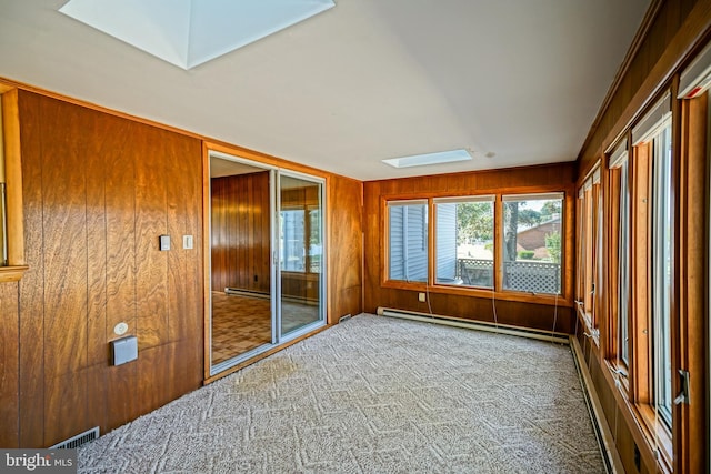 unfurnished sunroom featuring a skylight and a baseboard heating unit