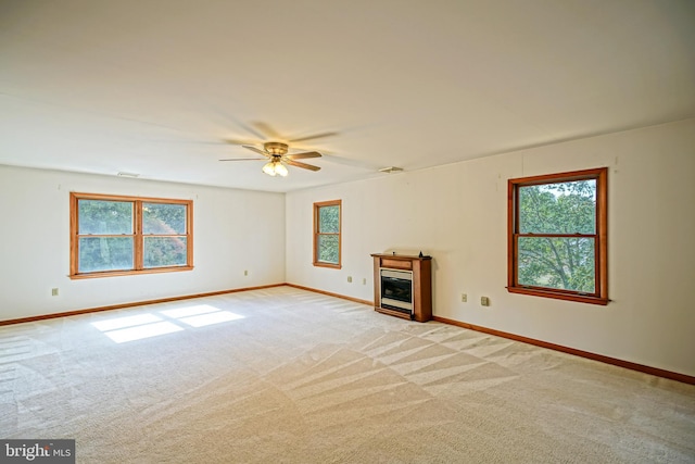 unfurnished living room with light colored carpet and ceiling fan