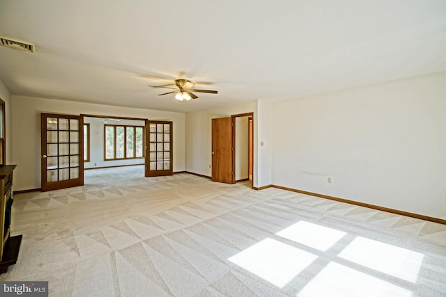 carpeted spare room with french doors and ceiling fan