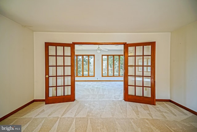 carpeted empty room featuring french doors and ceiling fan