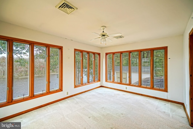 unfurnished sunroom with ceiling fan