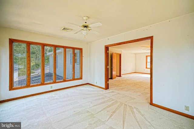 carpeted spare room with ceiling fan