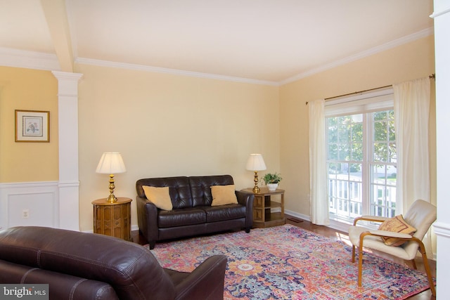 living room featuring crown molding, hardwood / wood-style flooring, decorative columns, and beamed ceiling