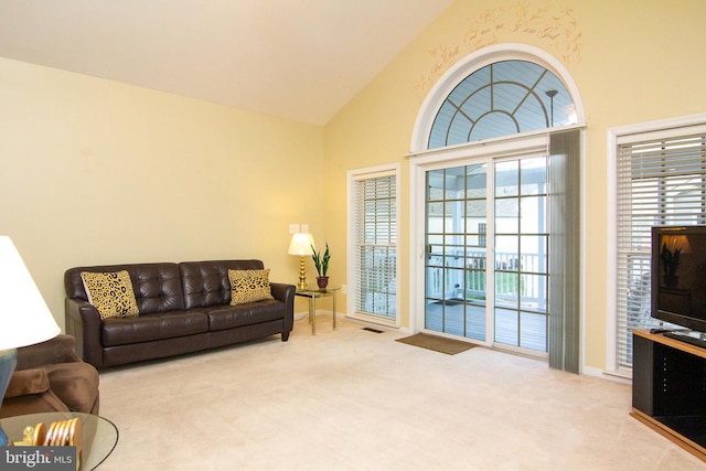 living room featuring light colored carpet and high vaulted ceiling