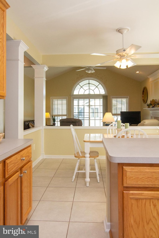 kitchen featuring lofted ceiling, ceiling fan, ornate columns, and light tile patterned floors