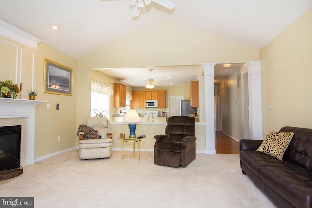 living room with ornate columns, light carpet, a premium fireplace, and lofted ceiling