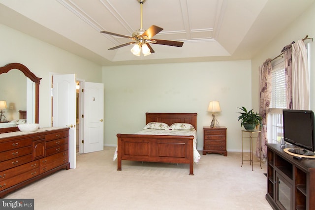 bedroom with a tray ceiling, light colored carpet, and ceiling fan