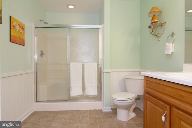 bathroom with toilet, walk in shower, vanity, and tile patterned flooring