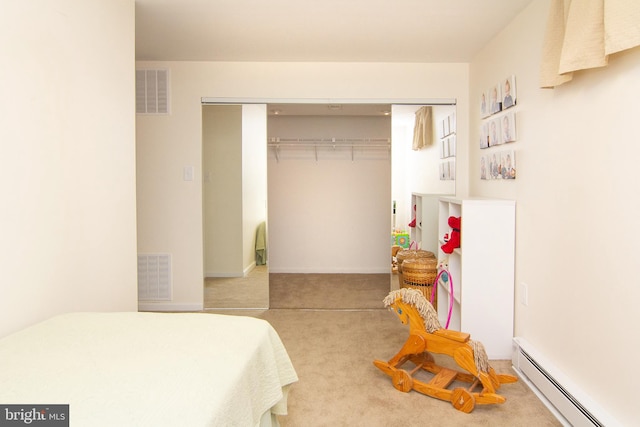 carpeted bedroom featuring a baseboard heating unit and a closet