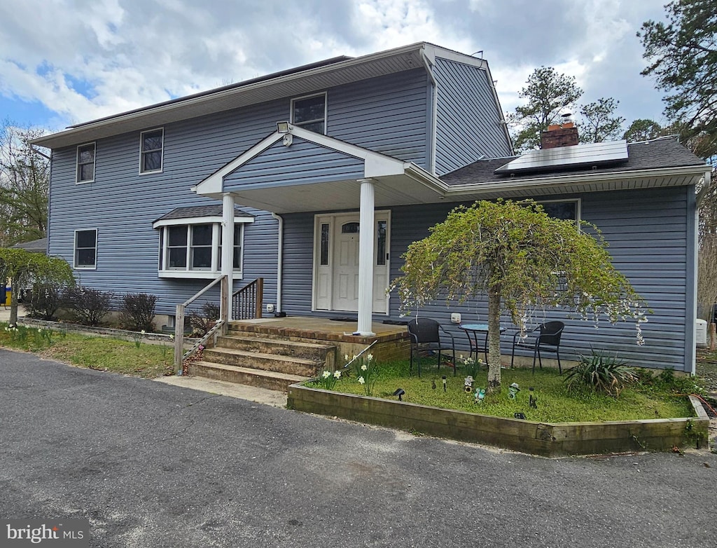 view of front of house featuring solar panels and a porch