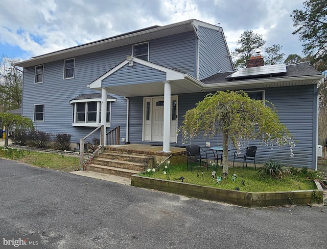 view of front of house featuring solar panels and a porch