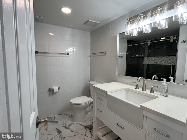 bathroom with vanity, toilet, and tiled shower