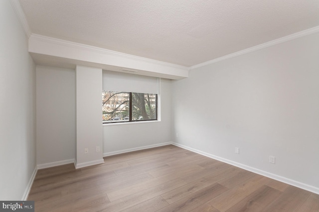 unfurnished room with light hardwood / wood-style floors, ornamental molding, and a textured ceiling