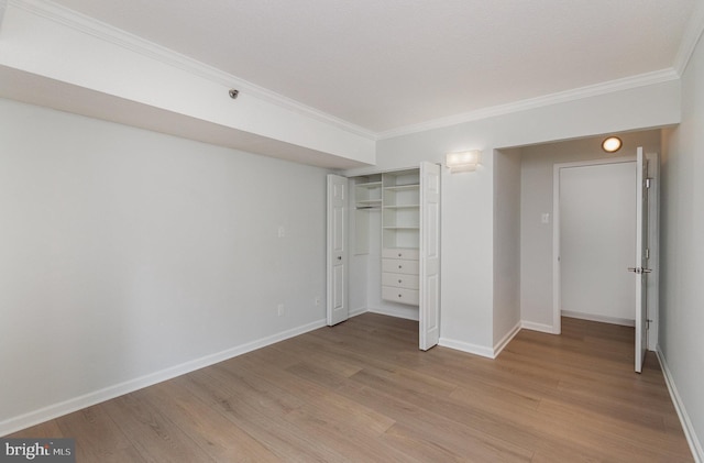 unfurnished bedroom with light hardwood / wood-style flooring, a closet, and ornamental molding