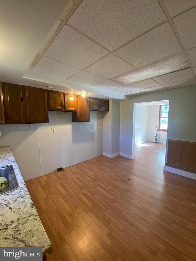 basement featuring a drop ceiling and hardwood / wood-style floors