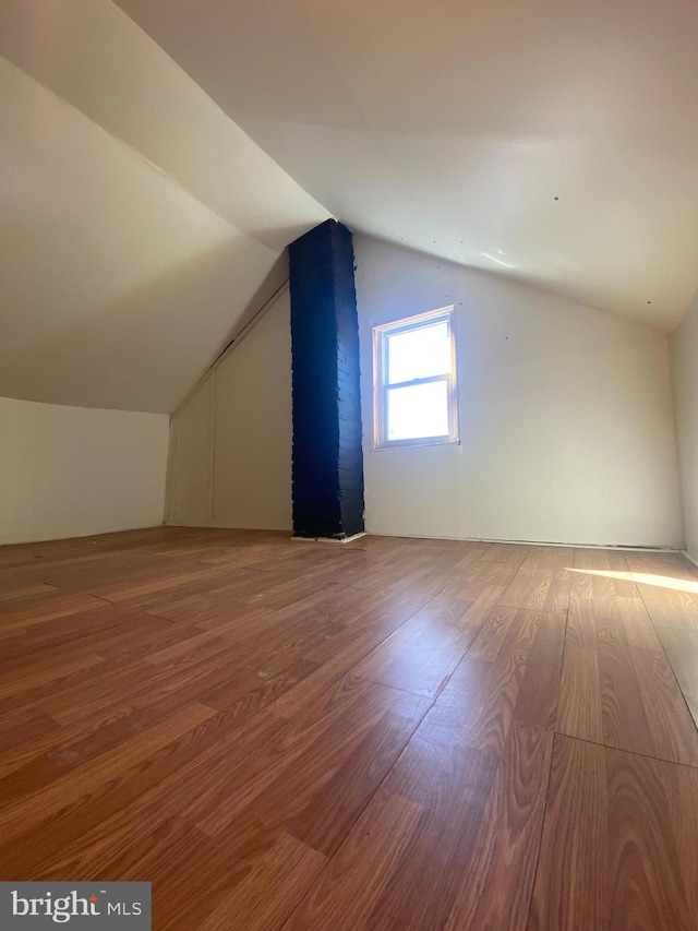 additional living space featuring lofted ceiling and hardwood / wood-style floors