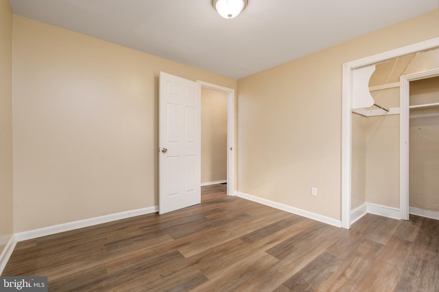 unfurnished bedroom with a closet and hardwood / wood-style floors