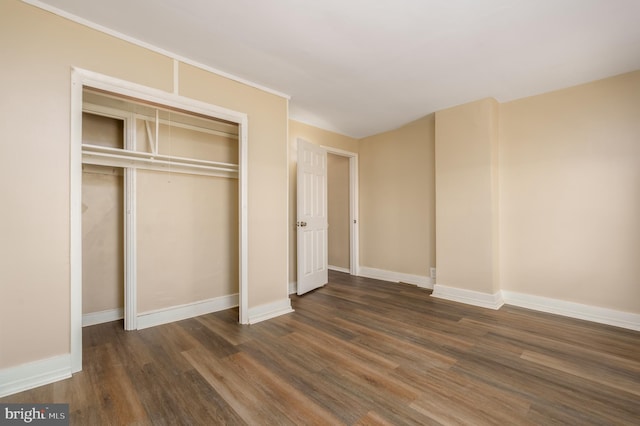 unfurnished bedroom featuring dark hardwood / wood-style floors and a closet