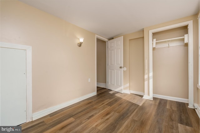 unfurnished bedroom featuring a closet and dark hardwood / wood-style floors