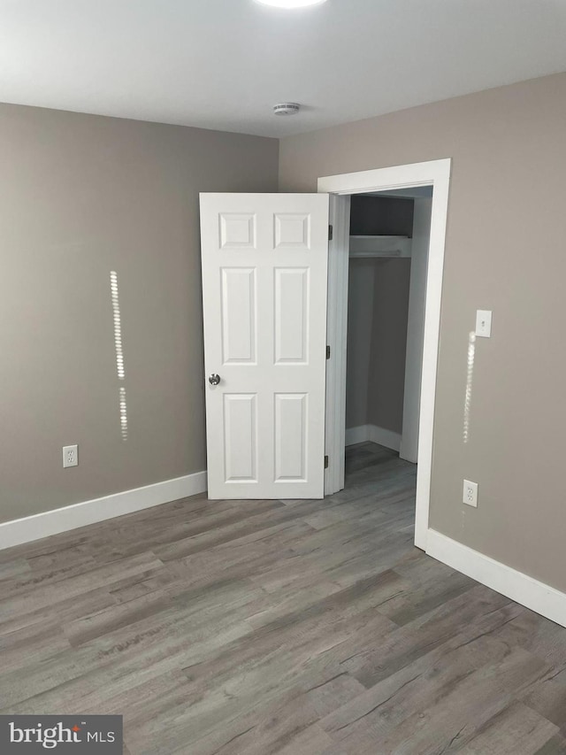 unfurnished bedroom with a closet and wood-type flooring