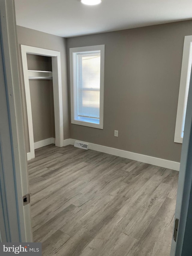 unfurnished bedroom featuring a closet and light hardwood / wood-style floors