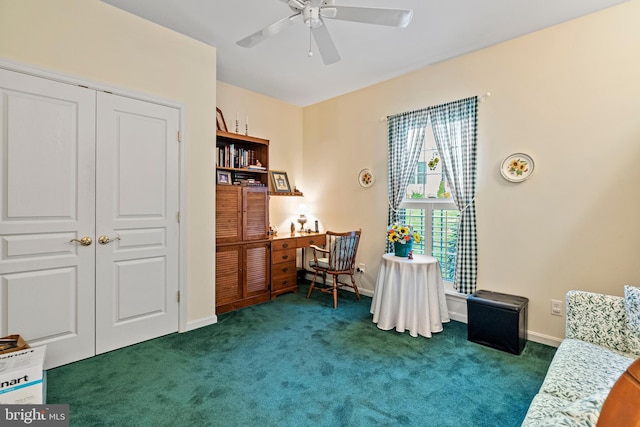 sitting room with ceiling fan and dark colored carpet