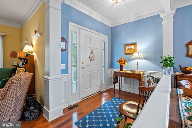 entryway featuring ornate columns, crown molding, and hardwood / wood-style floors