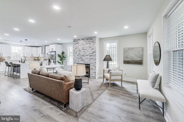 living room featuring light hardwood / wood-style floors, sink, and a fireplace