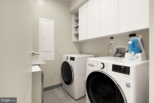 clothes washing area featuring electric panel, cabinets, and separate washer and dryer