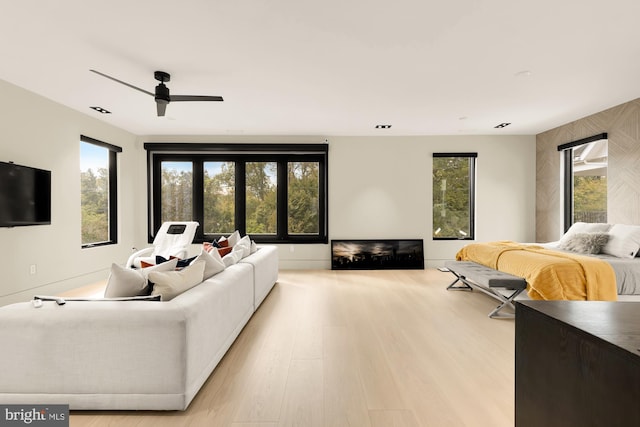 living room with light wood-type flooring and ceiling fan