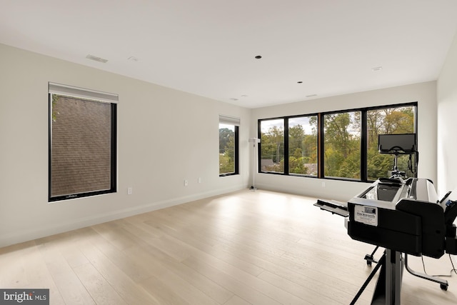 workout area with light hardwood / wood-style floors