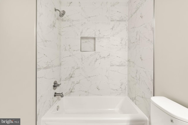 bathroom with toilet and tiled shower / bath combo