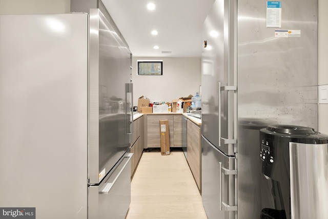 kitchen with light wood-type flooring and stainless steel fridge