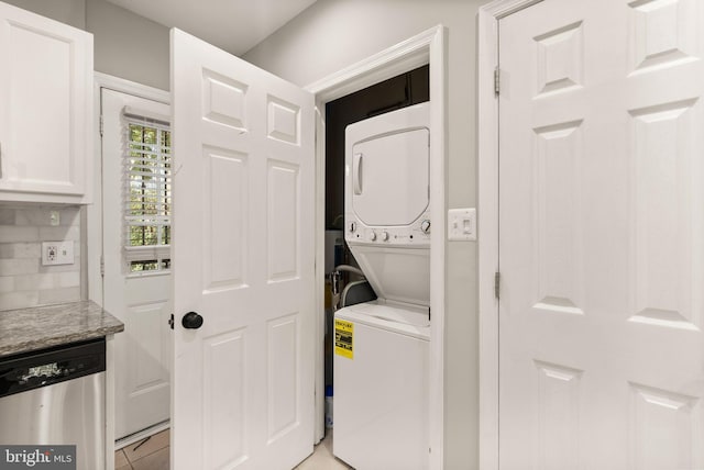 washroom with stacked washer and clothes dryer and light tile patterned floors