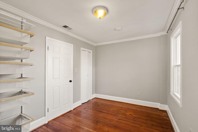 unfurnished bedroom with dark wood-type flooring, crown molding, and multiple windows