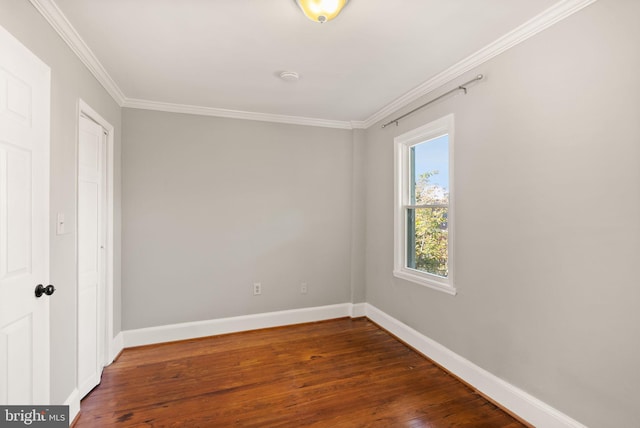 spare room with ornamental molding and dark hardwood / wood-style flooring