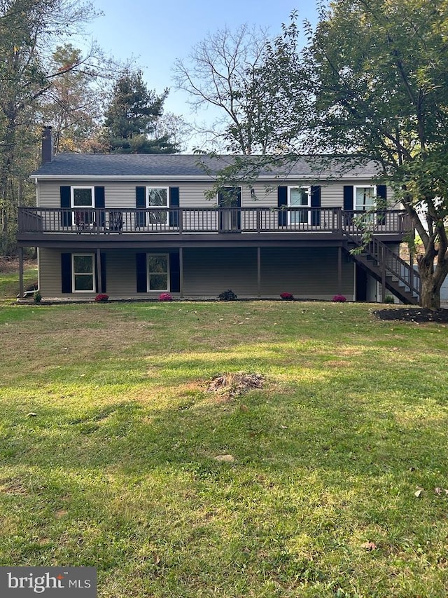 back of property with a lawn and a deck