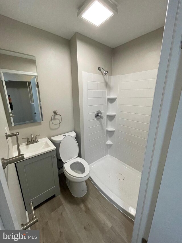 bathroom with vanity, toilet, a shower, and wood-type flooring