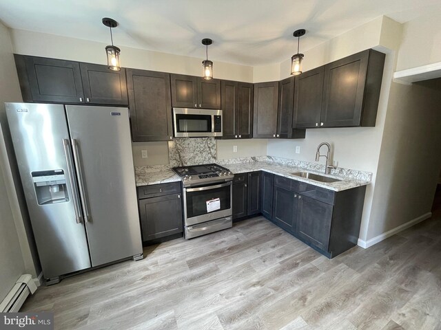 kitchen featuring appliances with stainless steel finishes, sink, baseboard heating, and hanging light fixtures