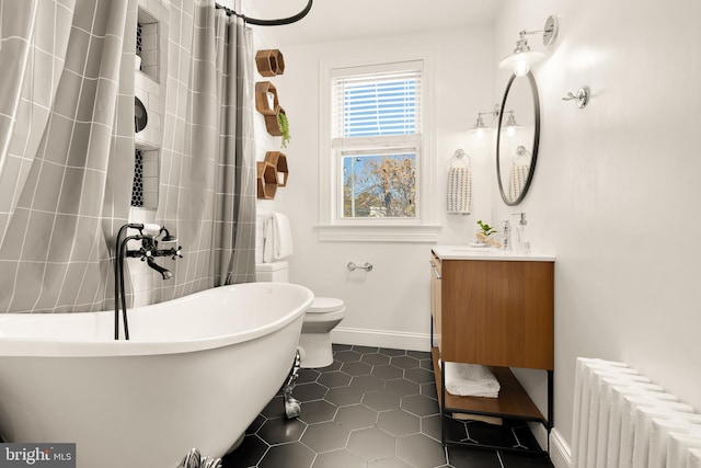 bathroom featuring a tub to relax in, radiator, vanity, tile patterned flooring, and toilet