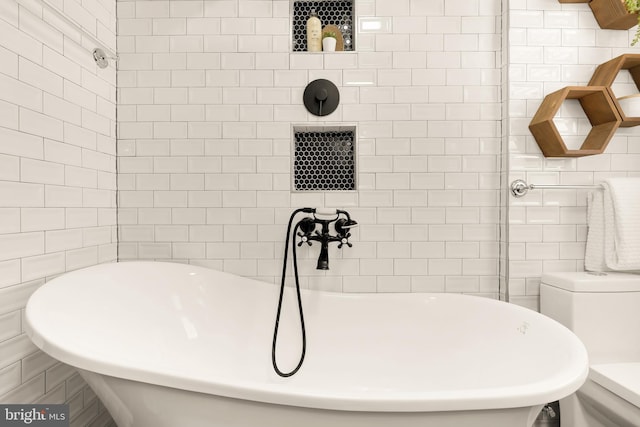 bathroom featuring a bathtub, toilet, and tile walls